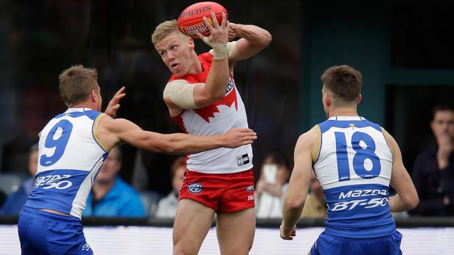 Dan Hannebery gets a handball away against North Melbourne.