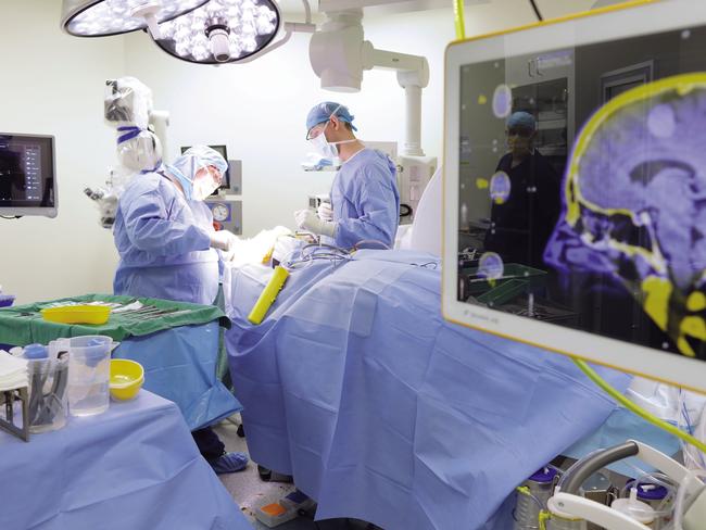 Supplied undated image obtained Wednesday, August 30, 2017 of medical professionals performing neurosurgery at the Ramsay Health Care-operated Greenslopes Private Hospital in Brisbane. Ramsay Health Care has lifted full-year net profit 8.6 per cent to $488.9 million on the back of growth in admissions and procedural volumes across the company's Australian business. The country's largest private hospital operator said revenue from services for the year to June 30 grew marginally, up 0.2 per cent, to $8.7 billion, from $8.68 billion a year ago. (Ramsay Health Care)  EDITORIAL USE ONLY