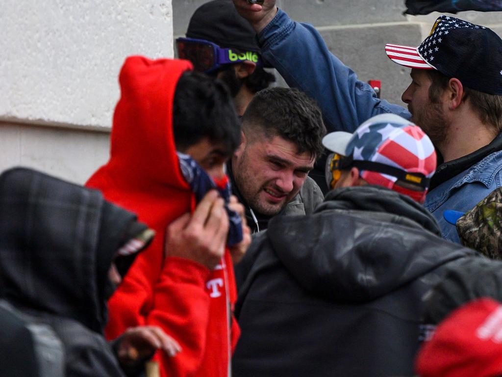 A Trump supporter affected by tear gas released by police as demonstrators laid siege to the US Capitol in Washington, DC. Picture: Andrew CABALLERO-REYNOLDS / AFP