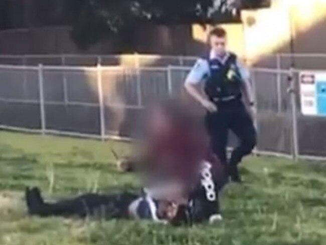 An officer is seen to circle the woman as she threatened the boy with a knife.