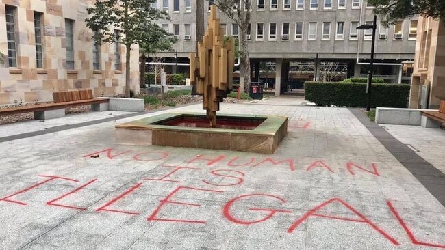 “No human is illegal” has been spray painted on the ground next to the red-dye fountain. Picture: Facebook