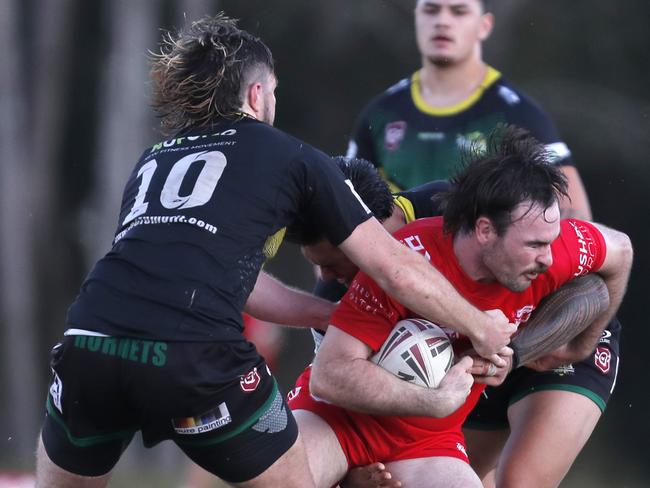 Ryan Jones of Currumbin Eagles is tackled by Cameron Newell and Liam Clark of Helensvale Hornets during the Rugby League Gold Coast A Grade clash held at Galleon Way, Gold Coast, Sunday, May 28, 2023. Photo: Regi Varghese