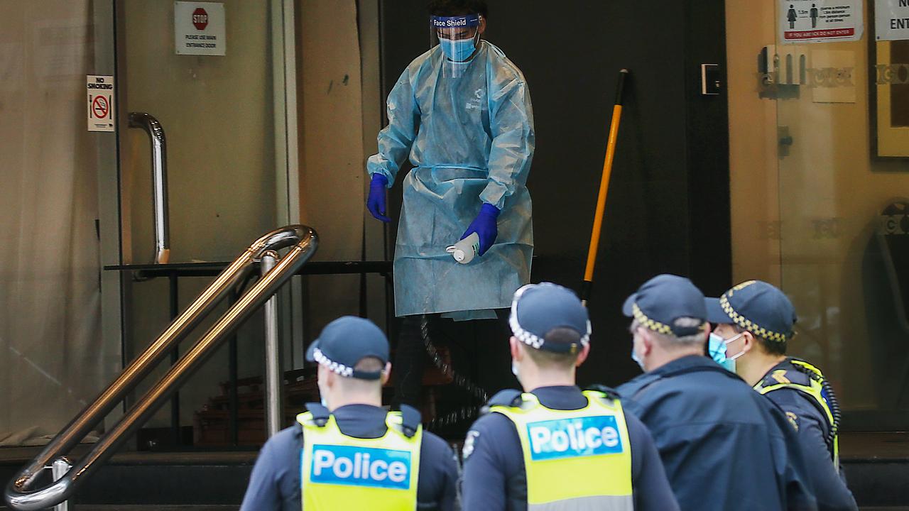 A man decontaminates the steps of the Hotel Grand Chancellor in Melbourne after a young woman who walked out was taken away by paramedics. Picture: NCA NewsWire/Ian Currie