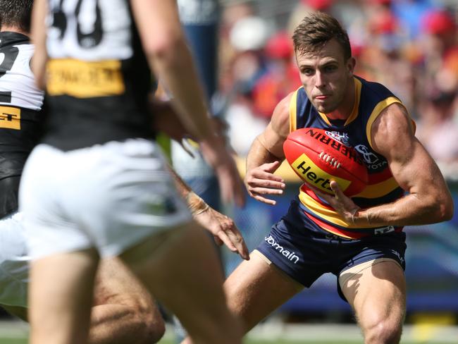 Brodie Smith of the Crows steps around a tackle from Charlie Dixon. Picture: Ben Macmahon (AAP)