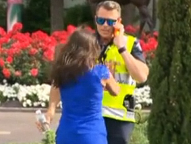 Melbourne Cup 2015’s ‘girl in the blue dress’ captured on film pushing a police officer into a garden bed at Flemington. Picture: Channel 7