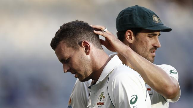 Josh Hazlewood is consoled by Mitchell Starc as he leaves the ground with a hamstring injury. Picture: Getty