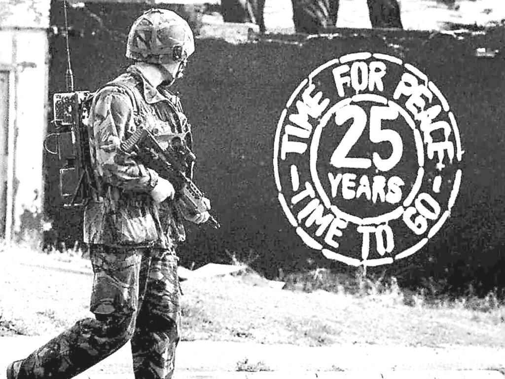 A British soldier patrolling Falls Road in Belfast, Northern Ireland on August 30, 1994 passes a graffiti message calling for peace in Northern Ireland after 25 years of violence. Picture: AP