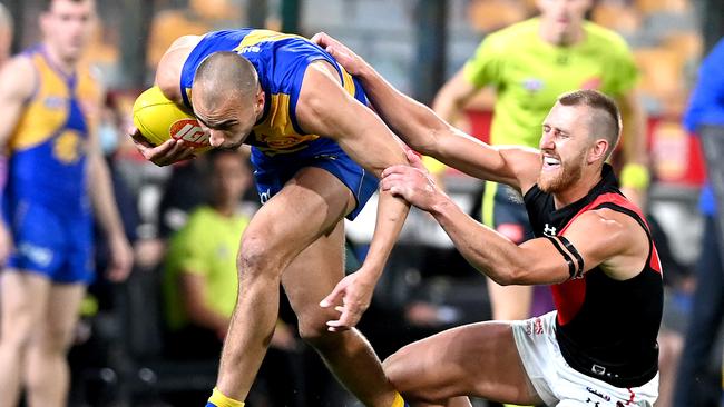 West Coast’s Dom Sheed attempts to break away from the tackle of Essendon’s returning star Dyson Heppell at the Gabba