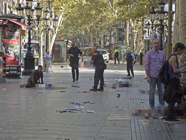 Police officers attend injured people moments after a van crashes into pedestrians in Las Ramblas, downtown Barcelona. Picture: EFE News Agency