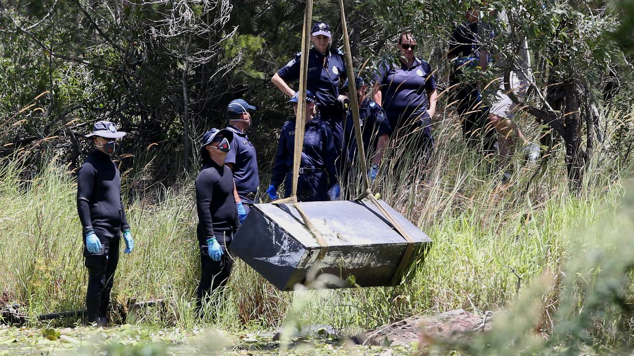 Police retrieve the metal box from the dam. Photo: Jono Searle.