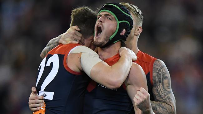 Angus Brayshaw, Aaron vandenBerg and James Harmes celebrate a goal.