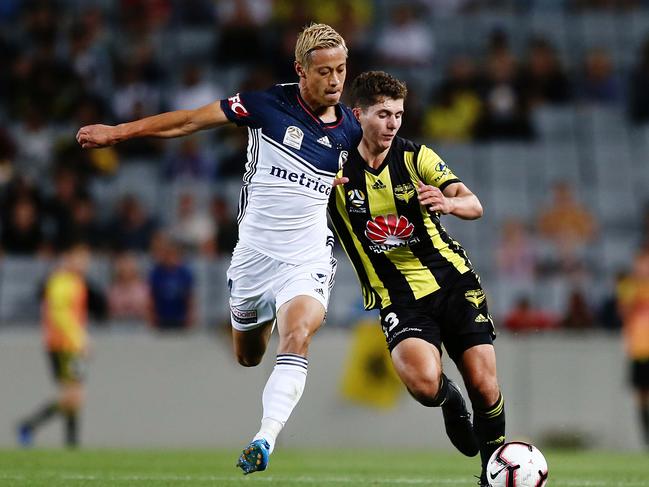 AUCKLAND, NEW ZEALAND - FEBRUARY 15: Liberato Cacace of the Phoenix competes against Keisuke Honda of the Victory during the A-League match between the Wellington Phoenix and the Melbourne Victory at Eden Park on February 15, 2019 in Auckland, New Zealand. (Photo by Anthony Au-Yeung/Getty Images)