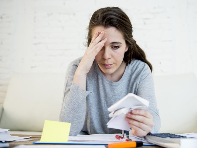 MONEY ISTOCK -  young attractive and desperate woman suffering stress doing domestic accounting paperwork bills and invoices worried and stressed at home sofa couch with bank folders and receipts Picture: Istock