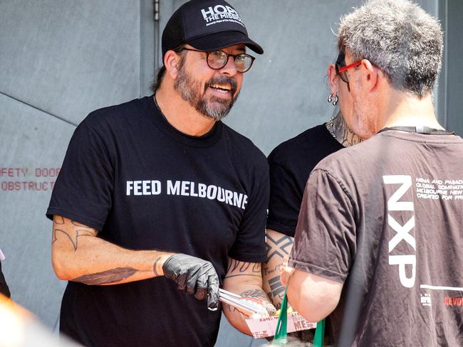 MELBOURNE, DECEMBER 8, 2023: Musician Dave Grohl serves food to the needy with The Big Umbrella, an emergency food relief organisation at Federation Square. Picture: Mark Stewart