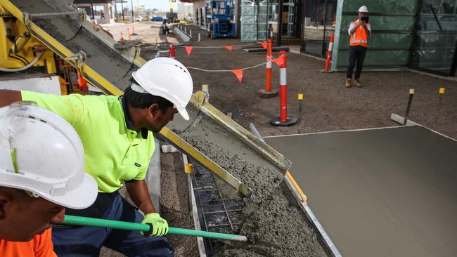 Construction workers pour concrete at the Coles Cobblebank site in Victoria, where six million pieces of recycled soft plastic went into the carpark, footpaths and curbing as a revolutionary concrete aggregate. Picture: supplied