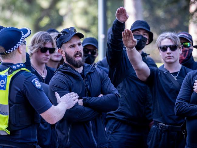 Stop Immigration Rally. National Socialist Network Neo-Nazis protest against a proposed increase to immigration. Campaign Against Racism and Fascism coalition stage a counter protest at State Parliament. Thomas Sewell speaks with police while members display the nazi salute. Picture: Jake Nowakowski