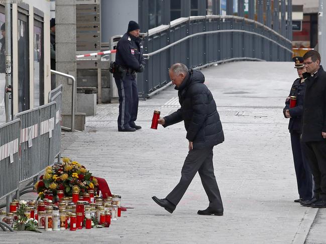 Austria's Interior Minister Gerhard Karner (L) places a candle at the site in Villach, Austria. Picture: AFP