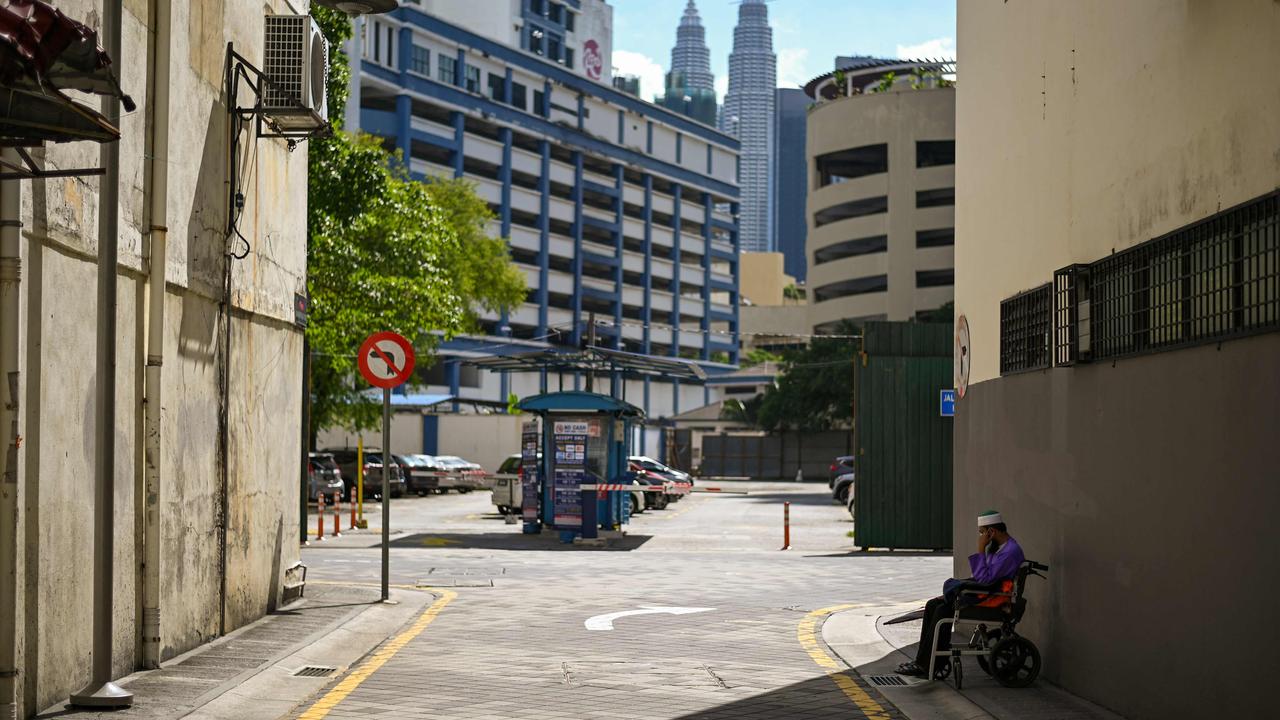 A man sits on his wheelchair as he begs on a backstreet in Kuala Lumpur. Picture: Mohd Rasfan / AFP