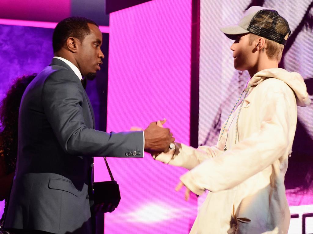 A suited up Diddy shakes hands with Justin Bieber onstage at the 2015 American Music Awards in LA. Picture: Frazer Harrison/AMA2015/Getty Images