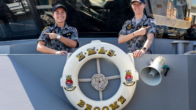 HMAS Broome Communication and Information Systems team, Able Seaman Louise Bliim (left) and Leading Seaman Jessica Steane, point to where they received their COVID-19 vaccinations while alongside in Darwin. Picture: Defence