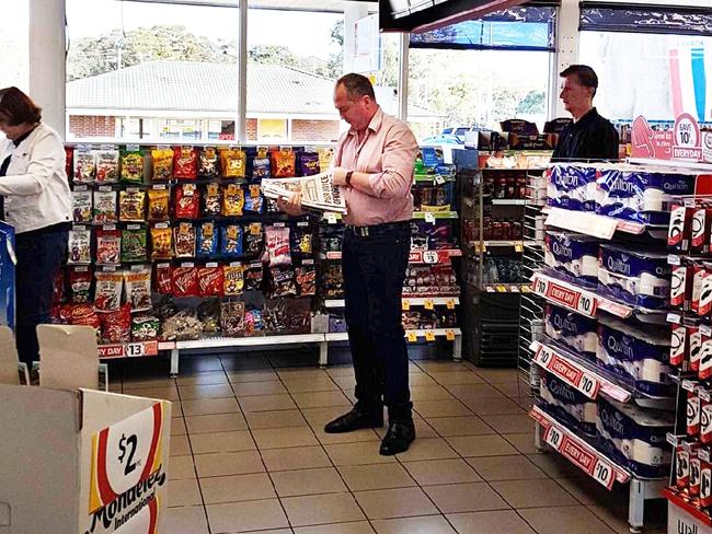 Barnaby Joyce reads the Daily Telegraph in a service station this morning. Supplied