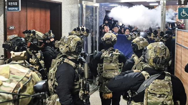 National Assembly staff sprays fire extinguishers to block soldiers entering the main hall of the National Assembly in Seoul. Picture: AP