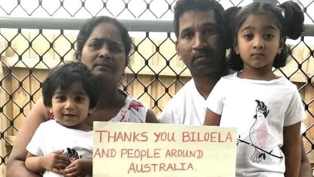 Priya, her husband Nadesalingam and their Australian-born children Tharunicaa, 2, and Kopika, 4, on Christmas Island on the weekend, hold a sign reading: “Thanks you Biloela and people around Australia. Your love gives us hope.” Picture: AAP