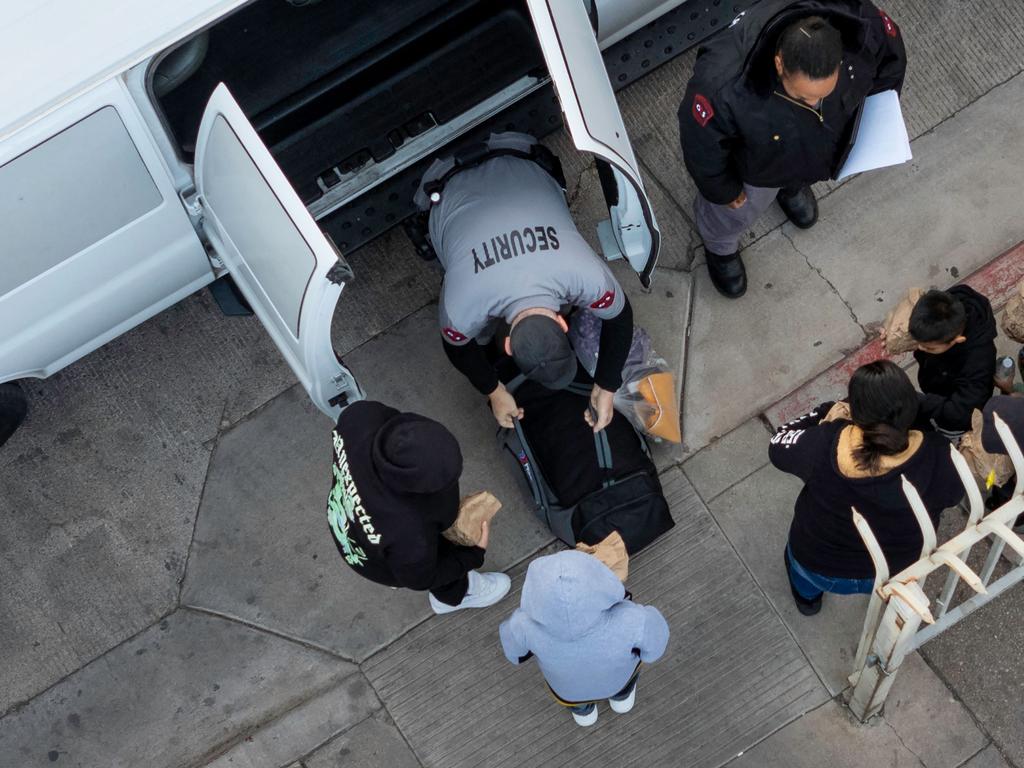 Deportees unload from a Customs and Border Protection transport vehicle while being sent back into Mexico in Nogales, Arizona. Picture: Getty Images via AFP