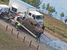 A small SUV is pulled out of the Burnett River under the inner city's main traffic bridge on October 16, 2024.