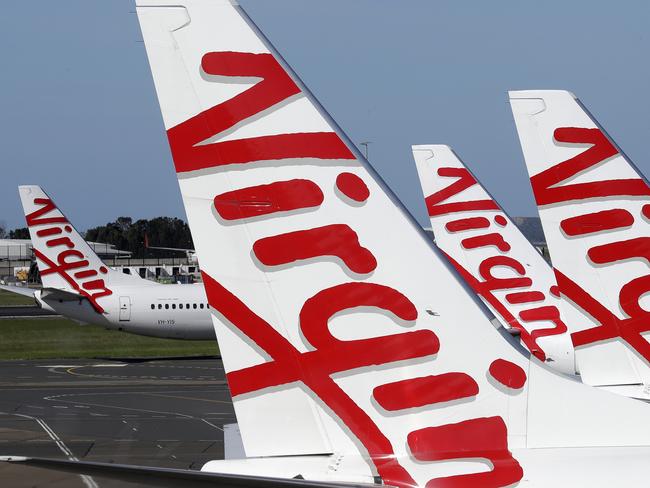 Virgin Australia planes are lined up at departure gates at Sydney Airport in Sydney, Wednesday, April 22, 2020. Virgin Australia is seeking bankruptcy protection, entering voluntary administration after a debt crisis worsened by the coronavirus shutdown pushed it into insolvency. (AP Photo/Rick Rycroft)