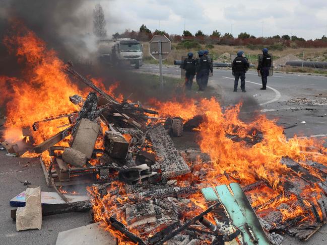 Gendarmes in riot gear stand guard to secure the access to the Frontignan oil depot in Southern France. Picture: AFP