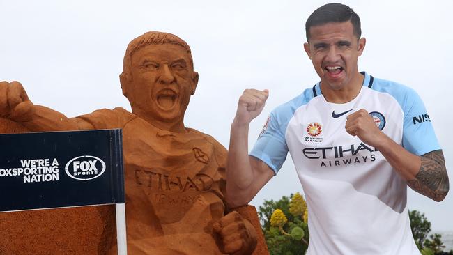 Tim Cahill at St Kilda Beach on Wednesday with a sand sculpture of himself.