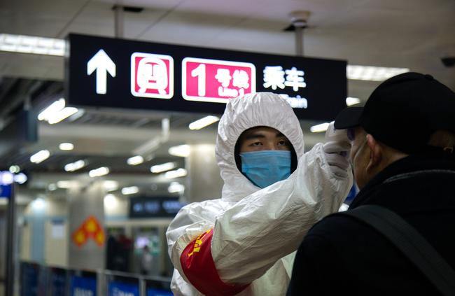 A health worker checks the temperature of a man entering the subway on Sunday in Beijing, China. Picture: Betsy Joles/Getty Images