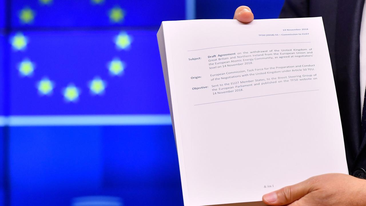 European Council President Donald Tusk holds the "draft agreement of the withdrawal of the United Kingdom of Great Britain and Northern Ireland from the European Union.