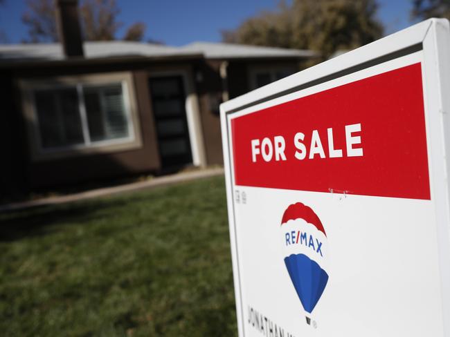 FILE - In this Oct. 22, 2019 file photo, a sign stands outside a home for sale in southeast Denver.  U.S. long-term mortgage rates were little changed this week of Dec. 23, remaining at historically low levels to prod prospective homebuyers.   (AP Photo/David Zalubowski, File)