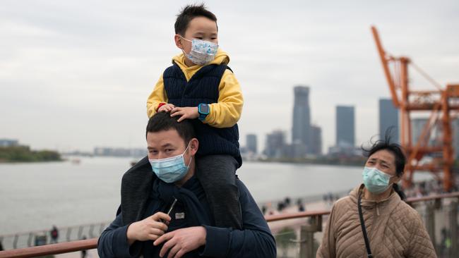 A family wearing protective masks during the covid outbreak in Shanghai, China, in April 2020. Picture: Getty