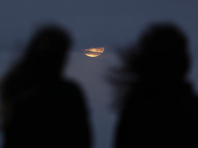 People watch the moon rising near Bondi Beach. Picture: AAP Image/Daniel Munoz