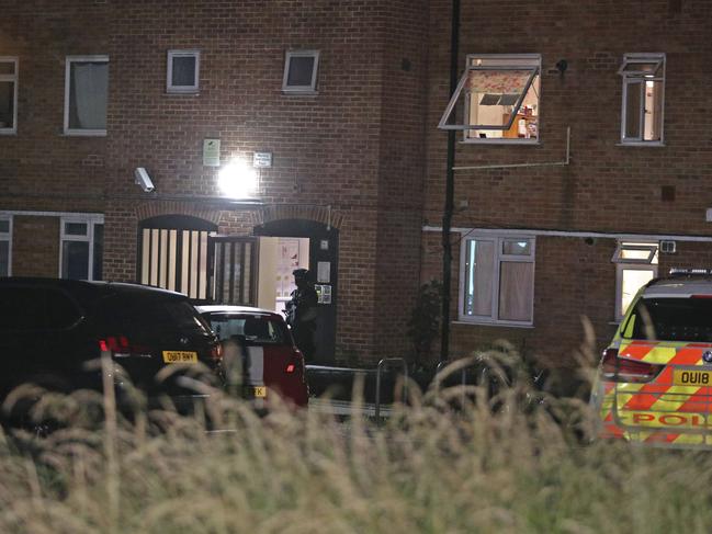 An armed police officer stands at a block of flats off Basingstoke Road in Reading after an incident at Forbury Gardens. Picture: AP