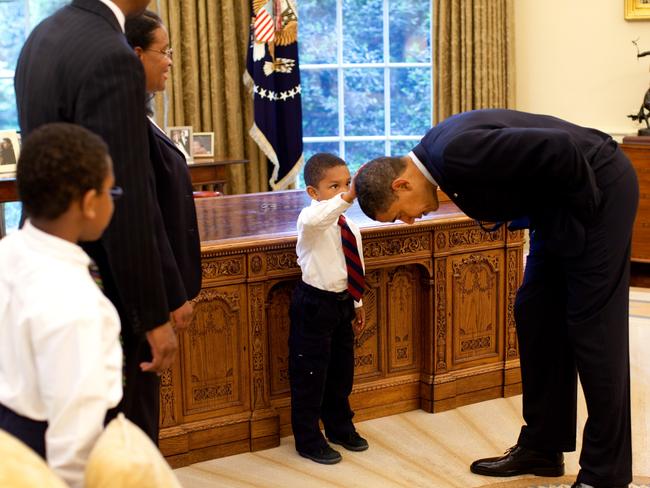 U.S. President Barack Obama bends over so the son of a White House staff member can pat his head during a visit to the Oval Office May 8, 2009 in Washington, DC. Picture: Pete Souza/The White House via Getty Images