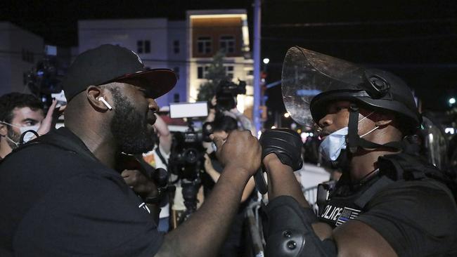 A Memphis Police officer fist bumps a protester in an attempt to bring the protest over the death of George Floyd to a peaceful conclusion in Memphis. Picture: AP