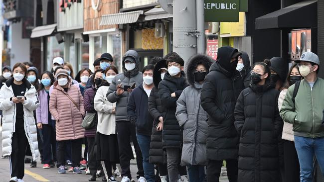 People wait in line to buy face masks from a store at the Dongseongro shopping district in Daegu, South Korea, on February 27.