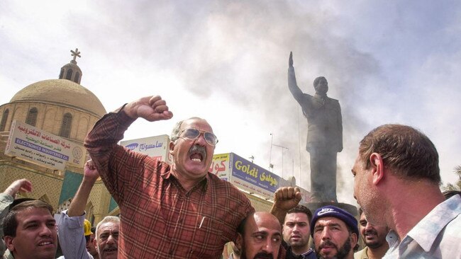 Protesters cheer as an effigy of Saddam Hussein is set alight in Baghdad. Picture: EPA/The Times