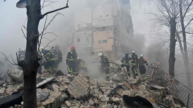 Ukrainian rescue workers and firefighters clear debris at the site of a missile attack in Kharkiv, the nation’s second-largest city. Picture: AFP