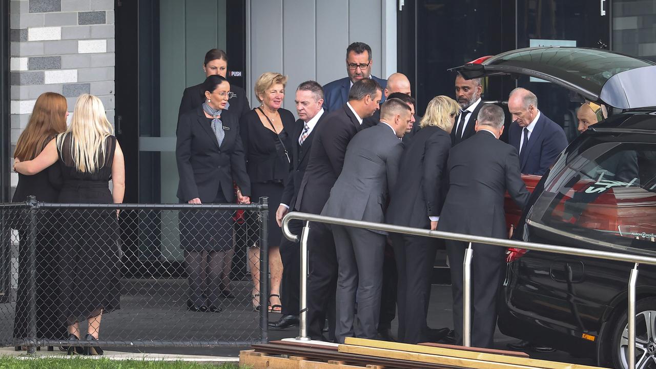 The coffin of Shane Warne is loaded into the hearse next to friends and family. Picture: David Caird