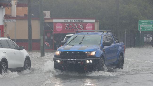 Major flooding in Currumbin Creek rd at Currumbin. Traffic sends waves through shops and factories. Picture: Glenn Hampson