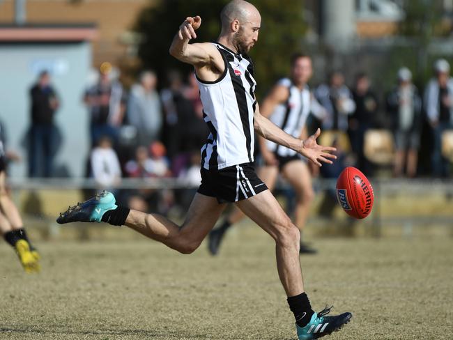 Adam Bronsgeest gets a kick away for Scoresby. Picture: James Ross/AAP