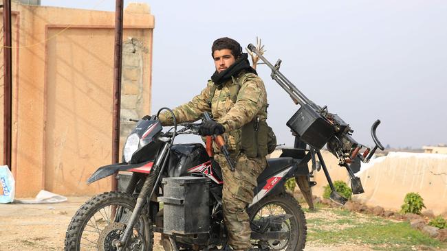 An anti-government fighter surveys the city of al-Rastan in Syria's west-central province of Homs. Picture: AFP