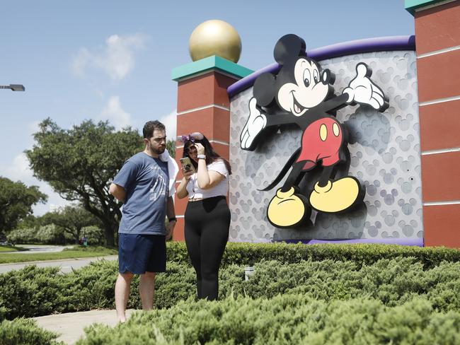 LAKE BUENA VISTA, FL - JULY 09: Michael Callahan and Sarah Breland look over photos taken near the Walt Disney World theme park entrance World on July 9, 2020 in Lake Buena Vista, Florida. The theme park is scheduled to reopen on Saturday despite a surge in new Covid-19 infections throughout Florida, including the central part of the state where Orlando is located.   Octavio Jones/Getty Images/AFP == FOR NEWSPAPERS, INTERNET, TELCOS & TELEVISION USE ONLY ==