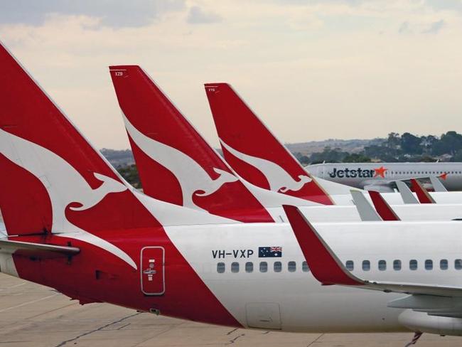MELBOURNE, AUSTRALIA - FEBRUARY 25: A Jetstar aeroplane prepares to take off as Qantas aeroplanes wait at Melbourne Tullamarine Airport on February 25, 2014 in Melbourne, Australia. On Thursday Qantas will announce their half year results, media reports suggest part of those announcements will include a large number of job cuts and the sale of their Melbourne terminal. (Photo by Scott Barbour/Getty Images)