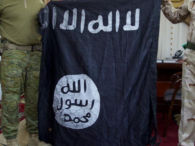 Lieutenant-Colonel David McCammon is presented with an Islamic State flag captured by Brigadier-General Salih Hariz’s 34th Brigade on the Mosul front.